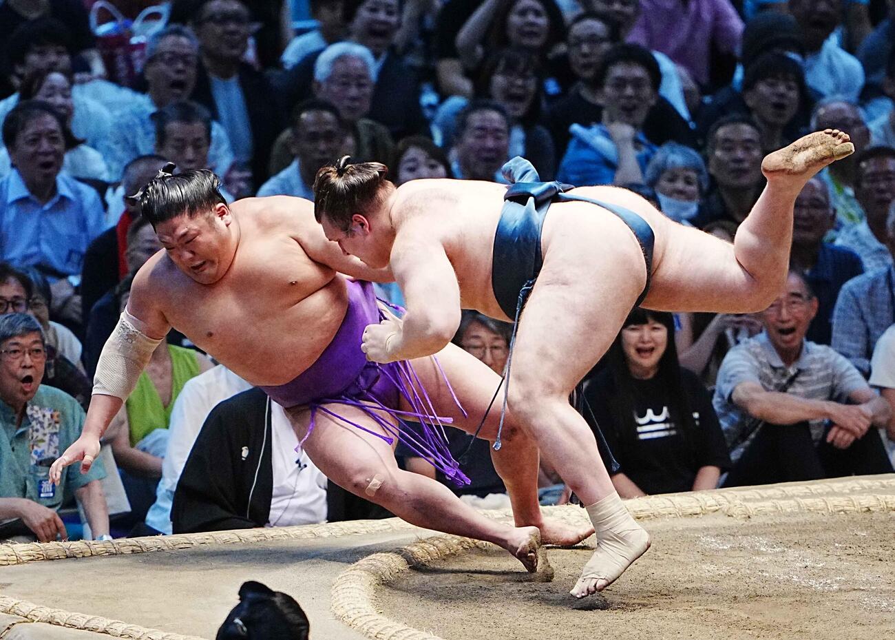 安青錦（右）は尊富士を寄り倒しで下す（撮影・小沢裕）