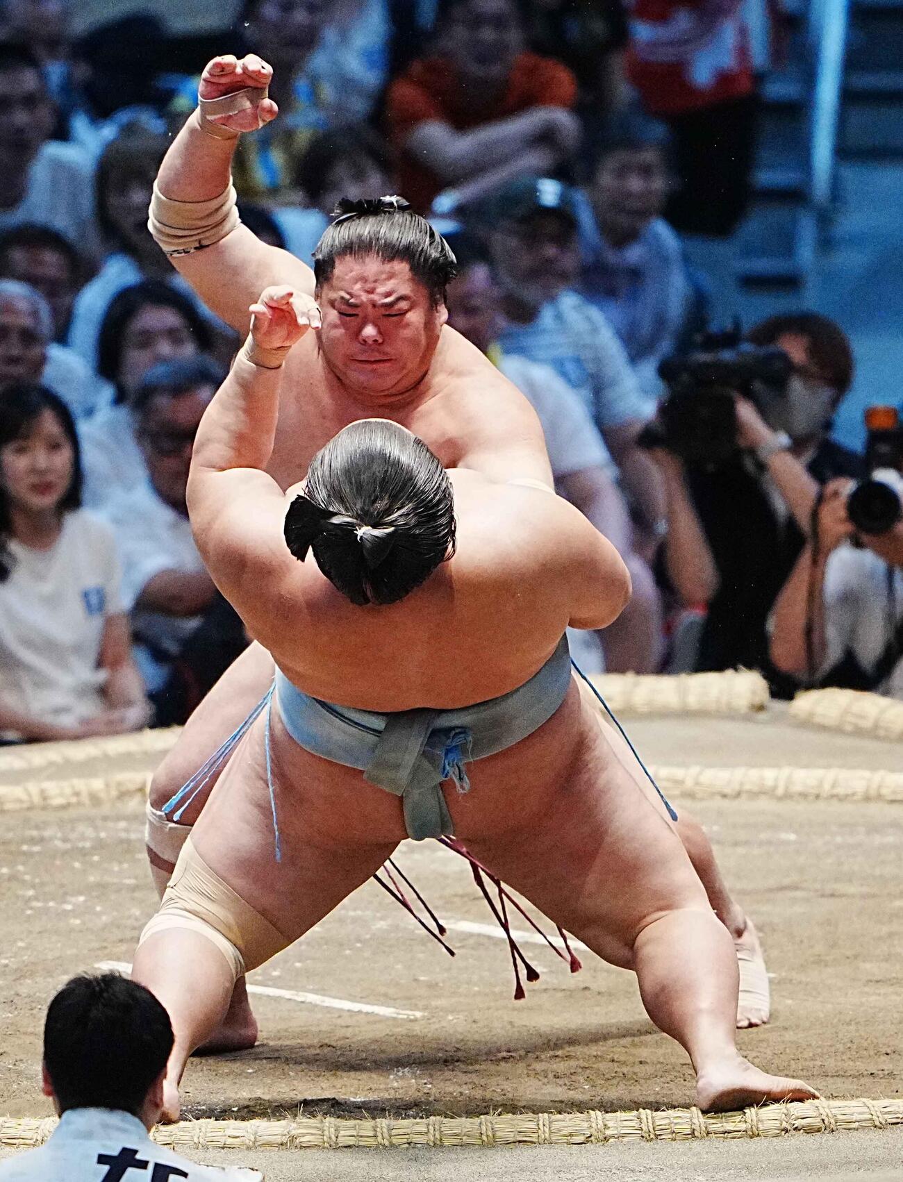 大栄翔（奥）の強烈な突き押しを身体を仰け反ってこらえる琴勝峰（撮影・小沢裕）