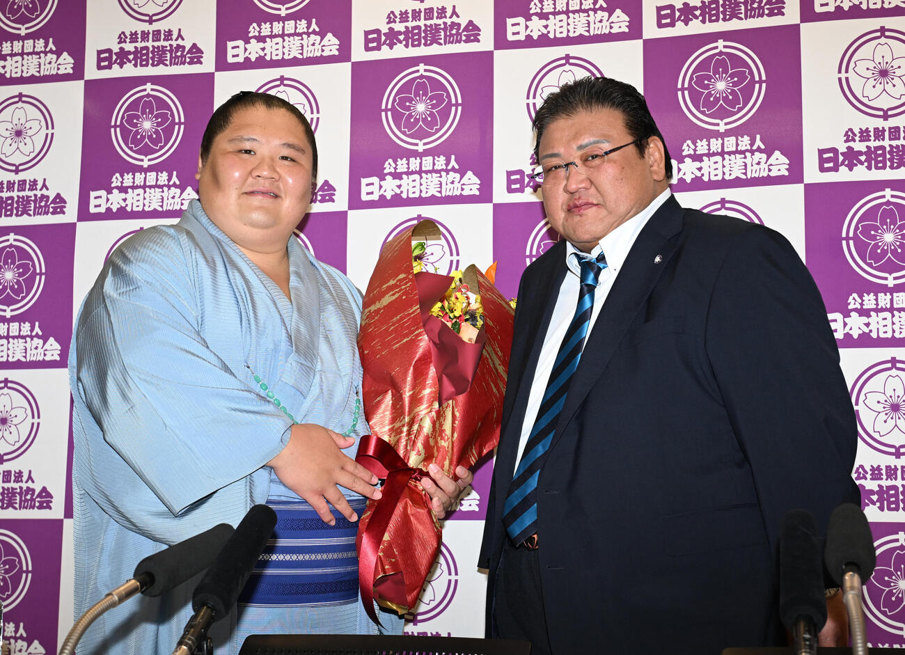 花束を手に追手風親方（右）と記念撮影する大翔丸（撮影・和賀正仁）
