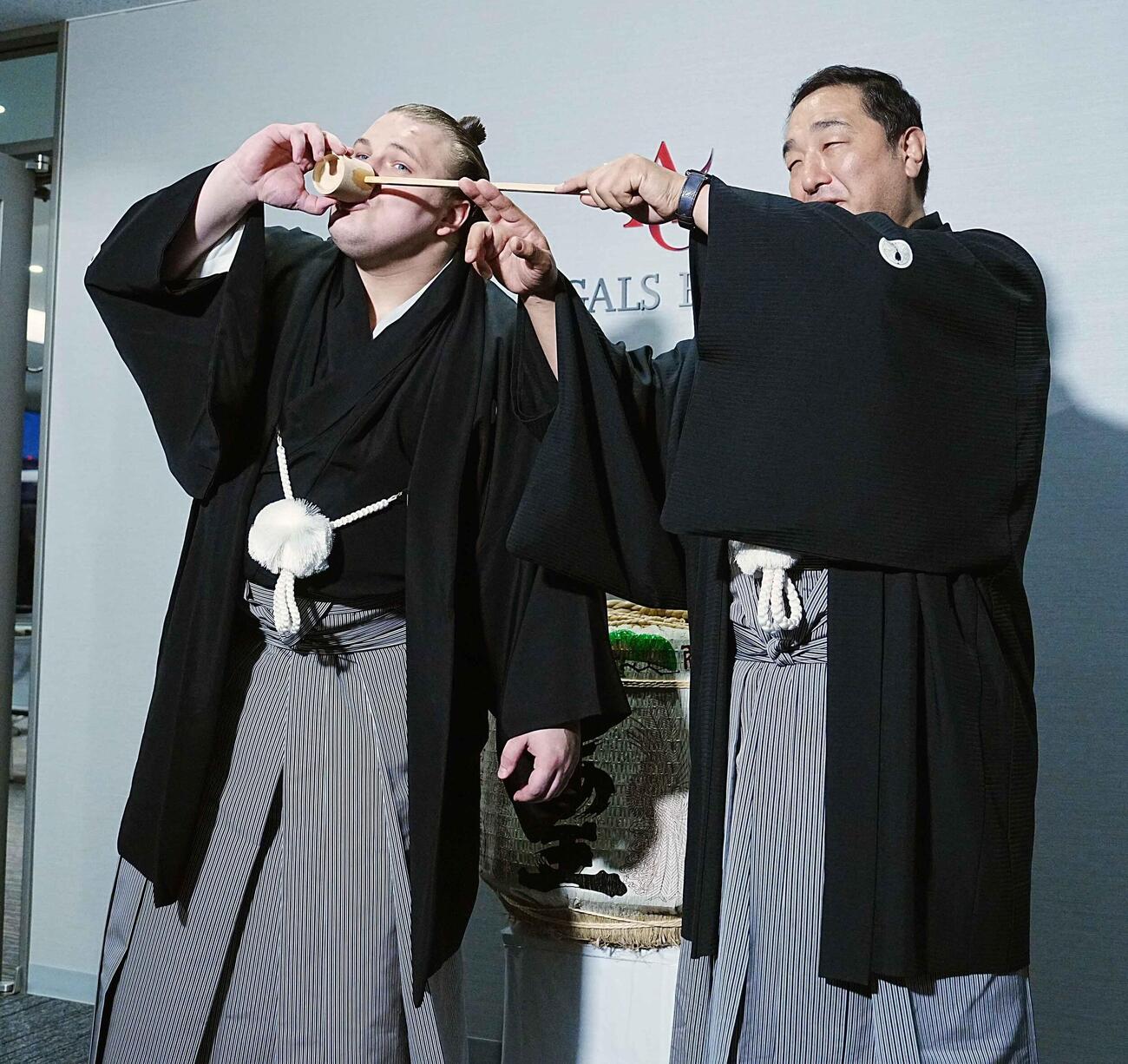 師匠の安治川親方（右）から水を付けてもらう安青錦（撮影・小沢裕）