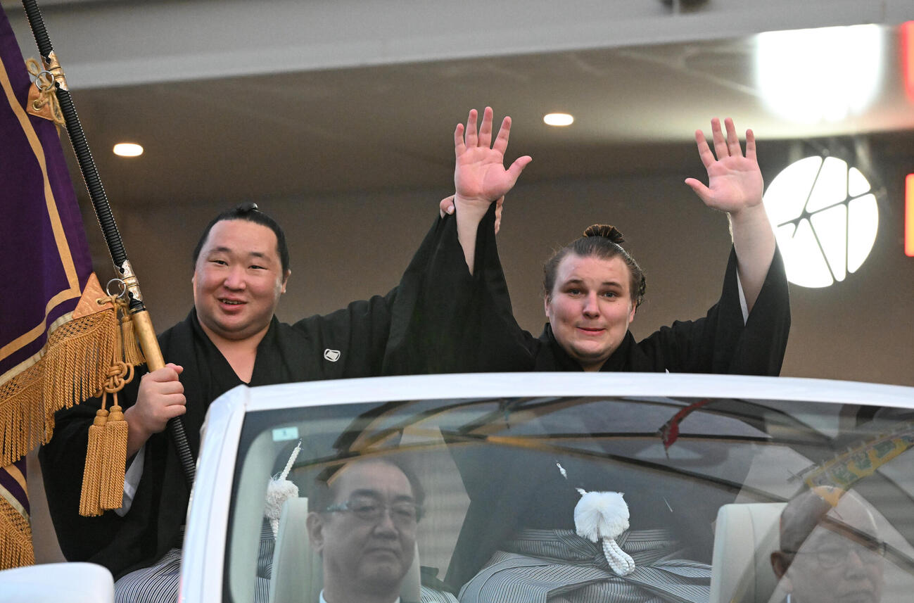 優勝パレードで旭海雄（左）に手を添えられバンザイする安青錦（撮影・和賀正仁）