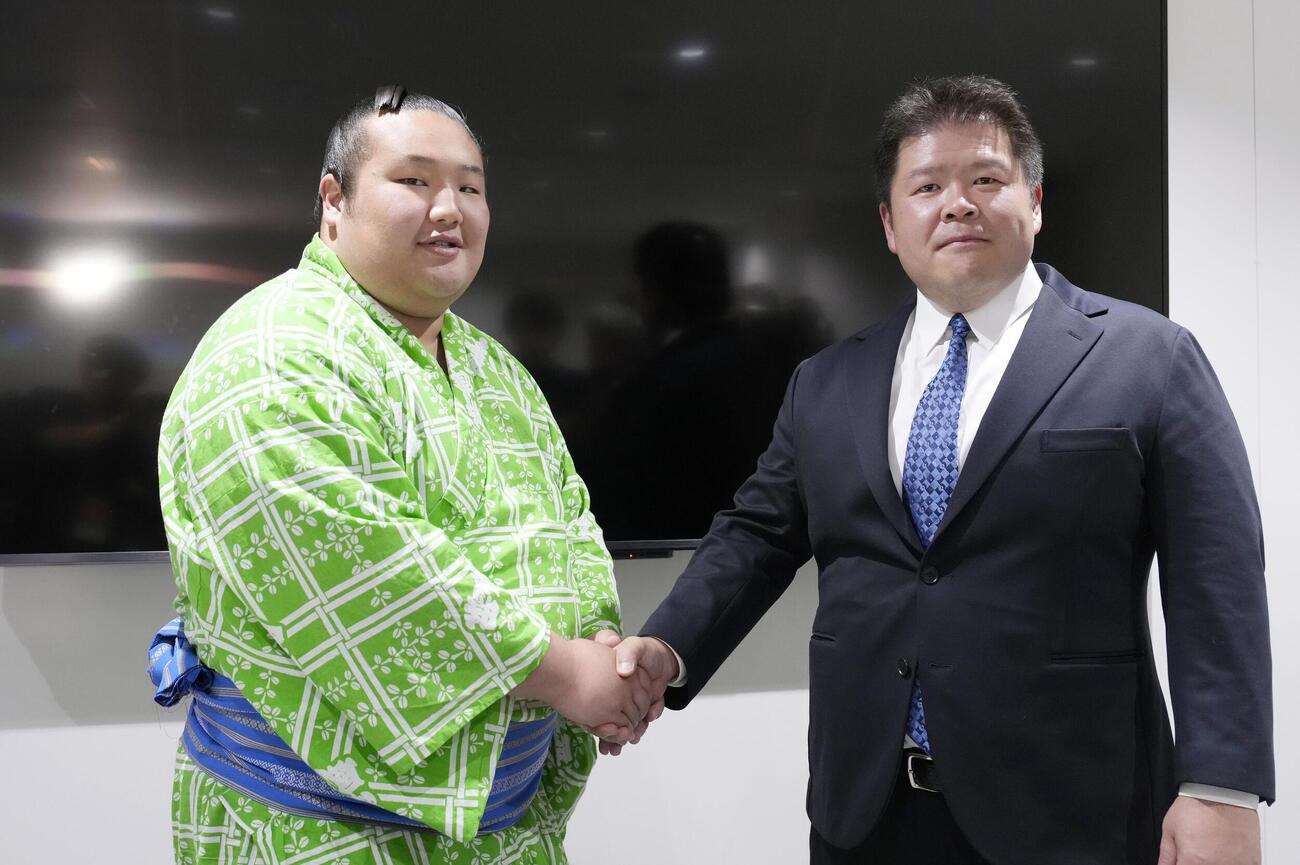 新十両昇進が決まり、時津風親方（右）と握手する時不動（共同）
