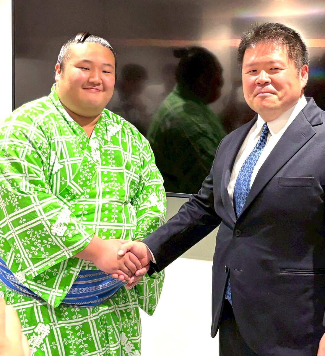 会見後に時津風親方（右）と握手する時不動（撮影・山田遼太郎）