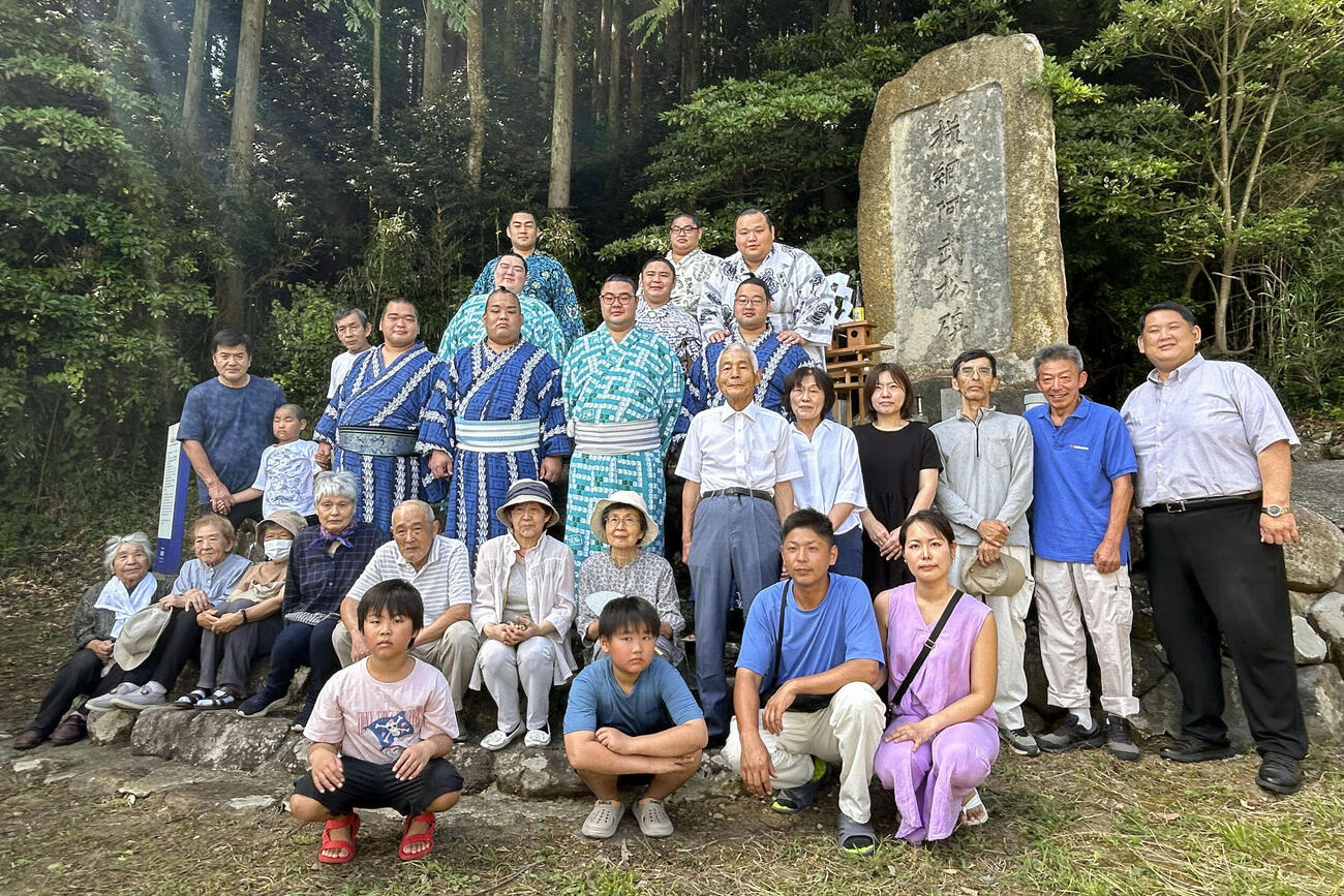 横綱阿武松の石碑の前で記念撮影する阿武松部屋の力士と地元住民（共同）