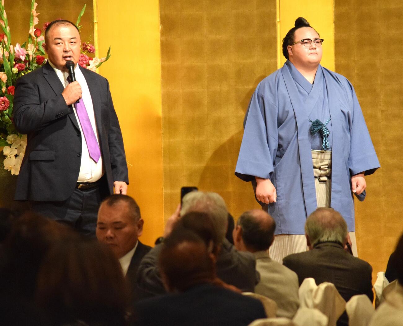 壇上であいさつをする荒汐親方（左）と丹治