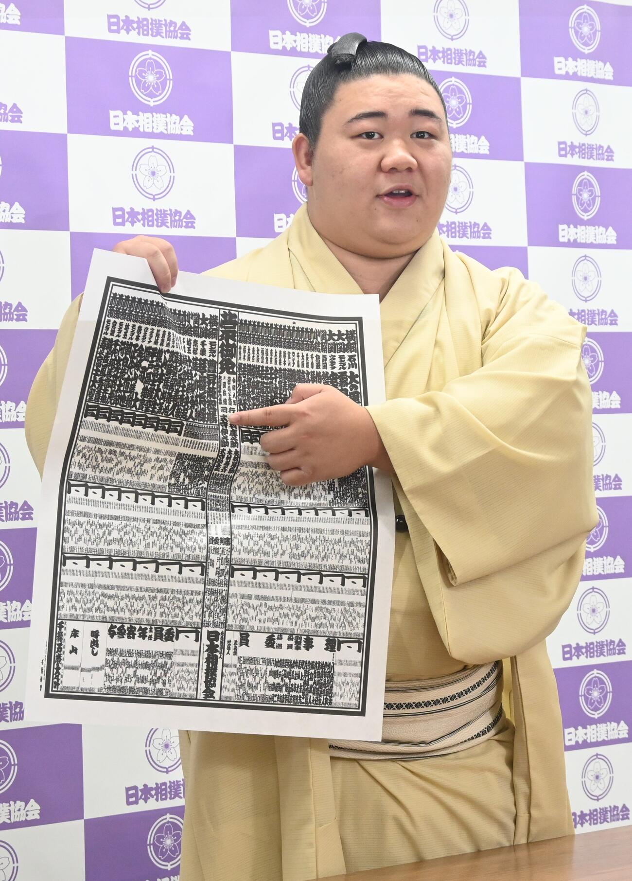 番付表を手にする新関脇の藤ノ川