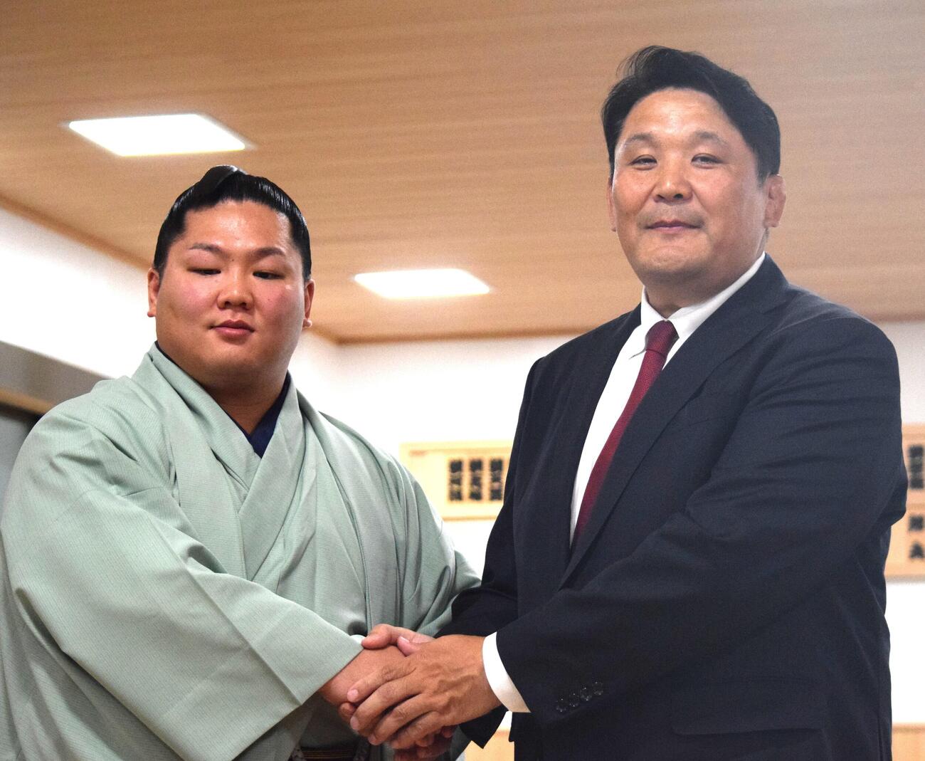 番付発表会見後に握手する朝翠龍（左）と高砂親方