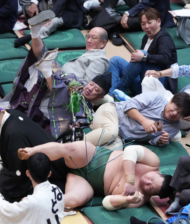 土俵下に押し出された東白龍。控え行司は式守慎之助（撮影・小沢裕）
