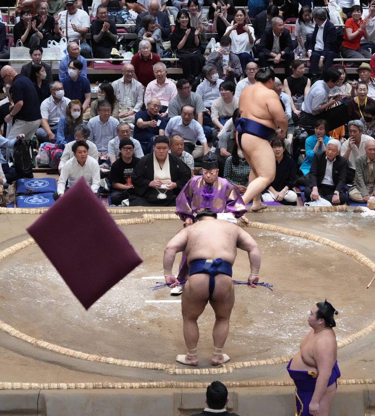 大の里は高安（手前）に1敗を喫し館内を座布団が舞うなか支度部屋へ引き揚げる（撮影・小沢裕）