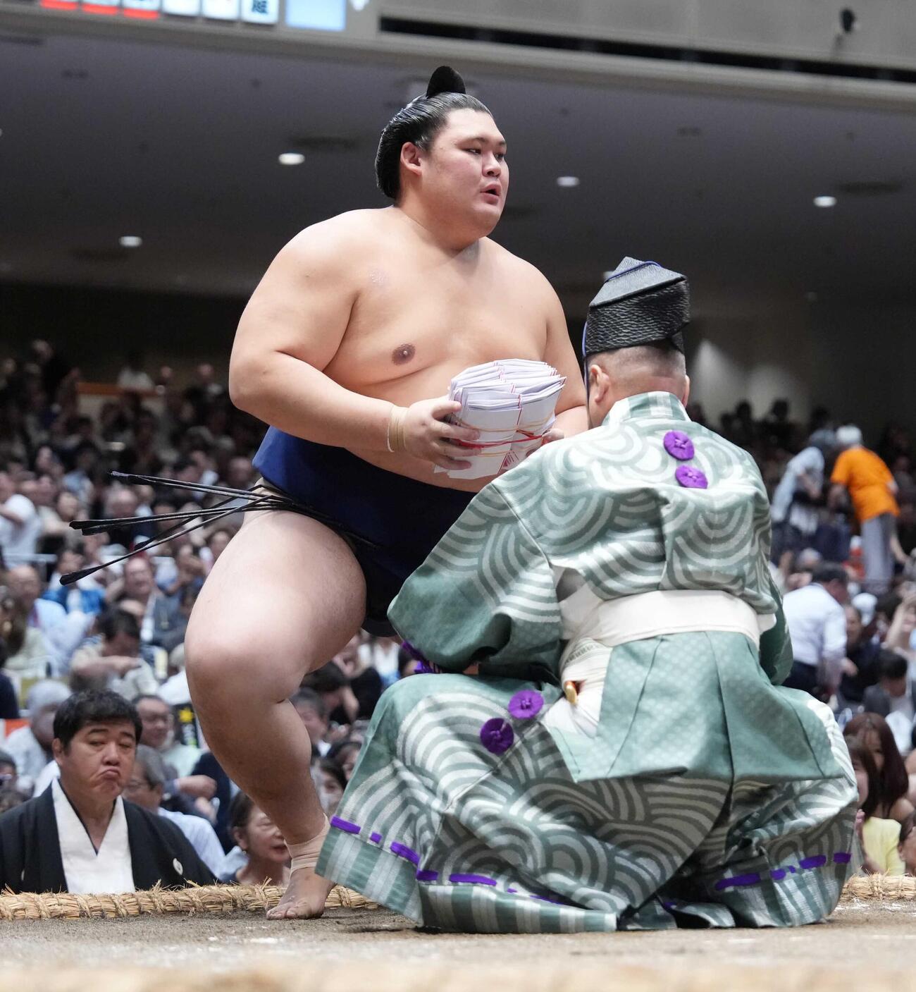 懸賞の束を手にする大の里（撮影・小沢裕）