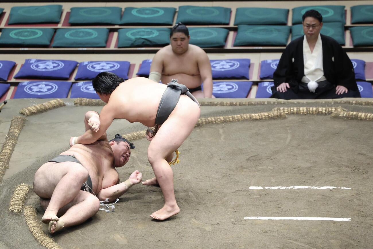 絢ノ富士（左）を掬い投げで破る垣添。後方右は雷親方（撮影・河田真司）