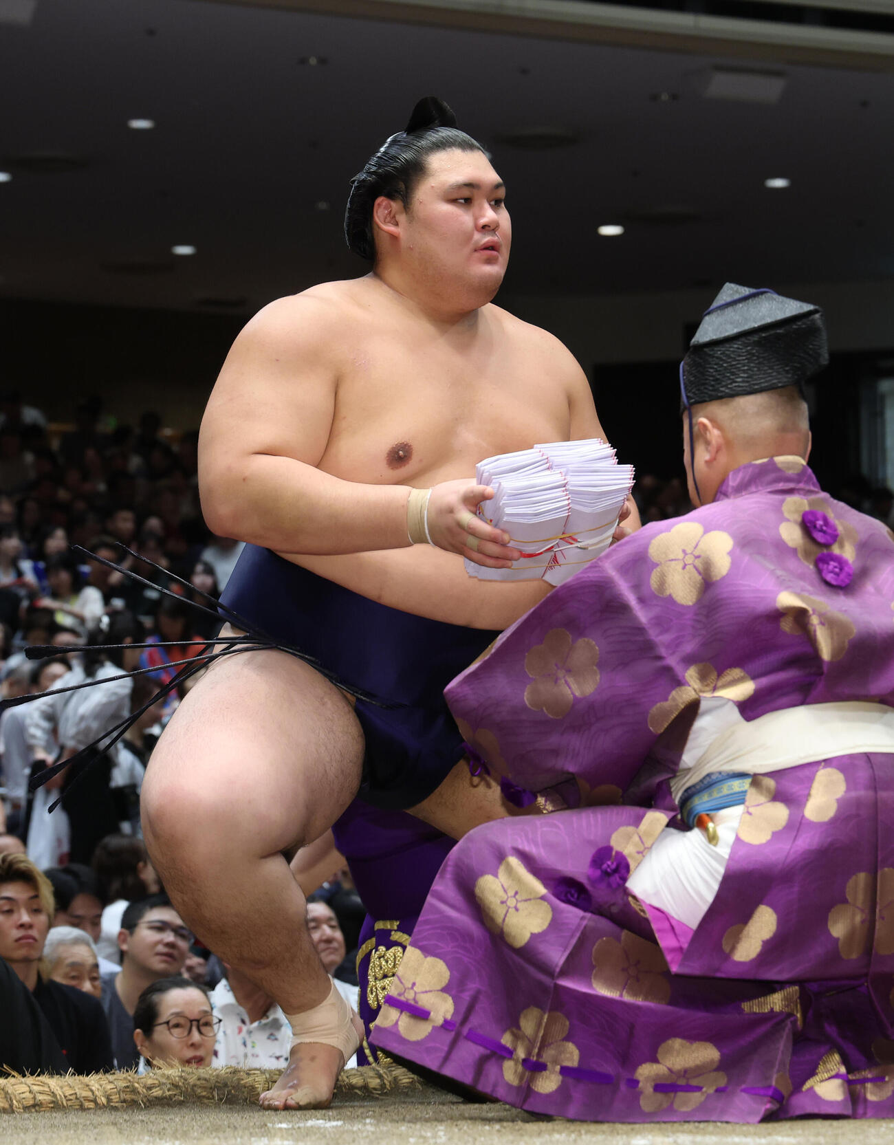 藤凌駕を引き落としで破り、懸賞金の束を手に土俵から引き揚げる大の里（撮影・河田真司）