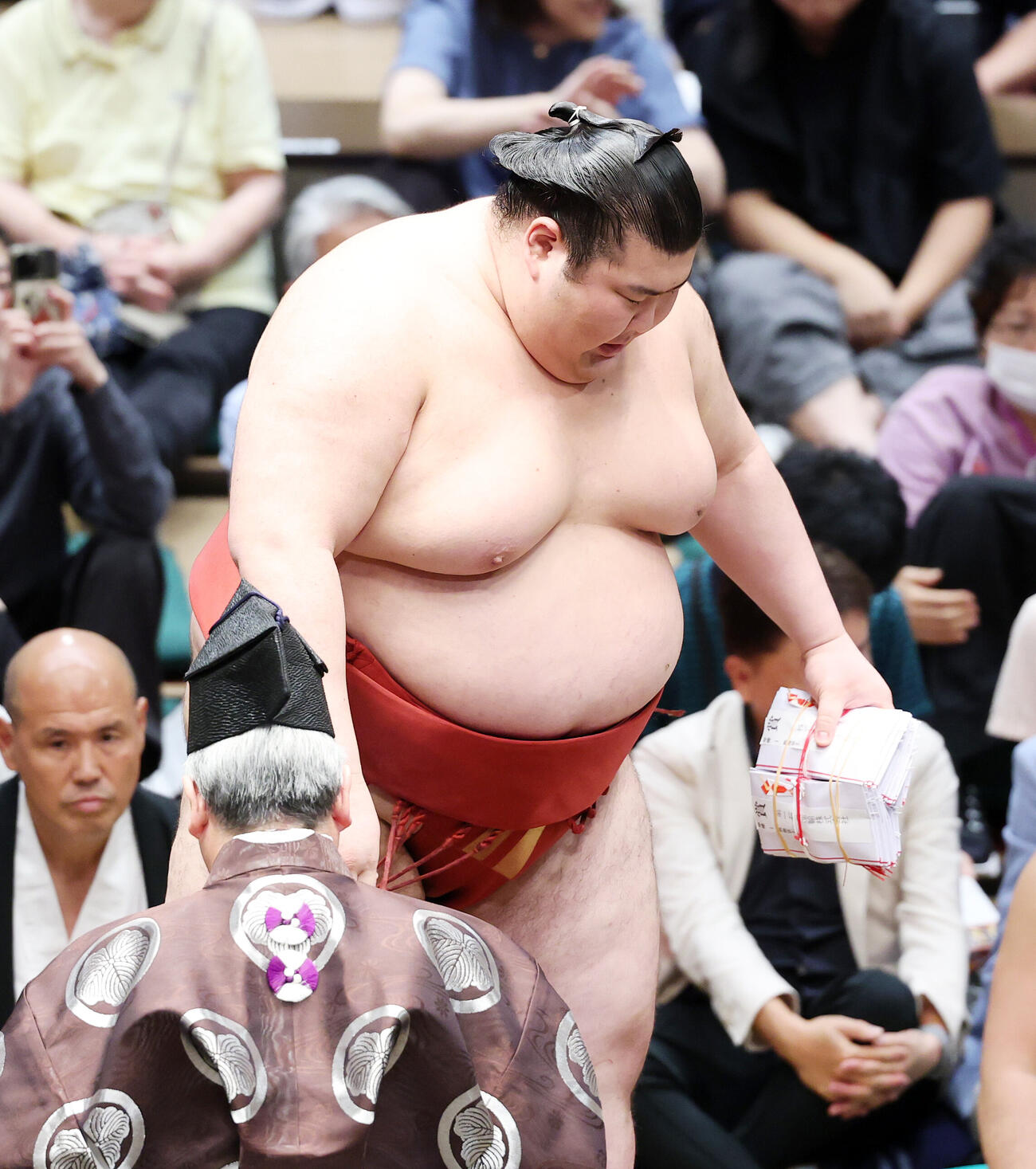 懸賞金の束を手に土俵を引き揚げる熱海富士（撮影・鈴木正人）