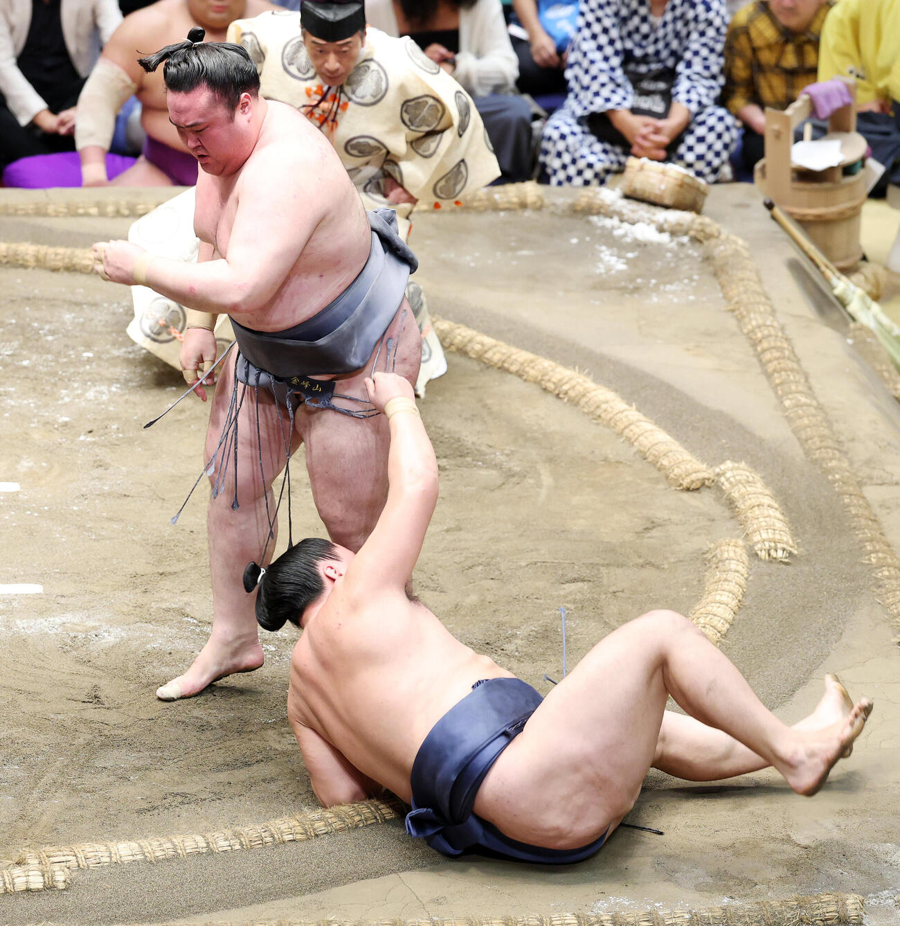 寿之富士（下）を下手投げで破る金峰山（撮影・鈴木正人）