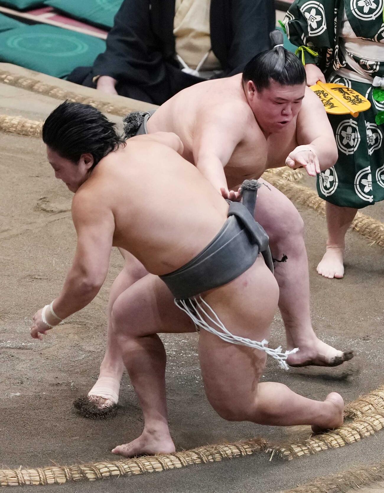 序二段の垣添（左）は三段目の納谷に送り倒しで敗れる（撮影・小沢裕）