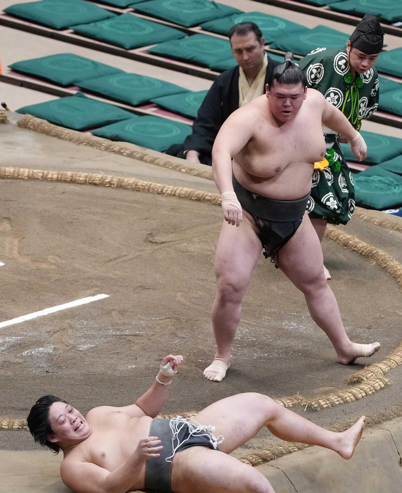 序二段の垣添（左）は三段目の納谷に送り倒しで敗れる。力の差を感じたのか苦笑いを浮かべていた（撮影・小沢裕）