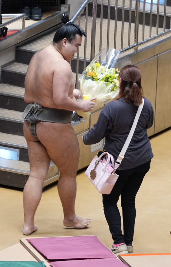 現役最後の取組を終えた朝阪神（左）は女性ファンから花束を贈呈される（撮影・小沢裕）