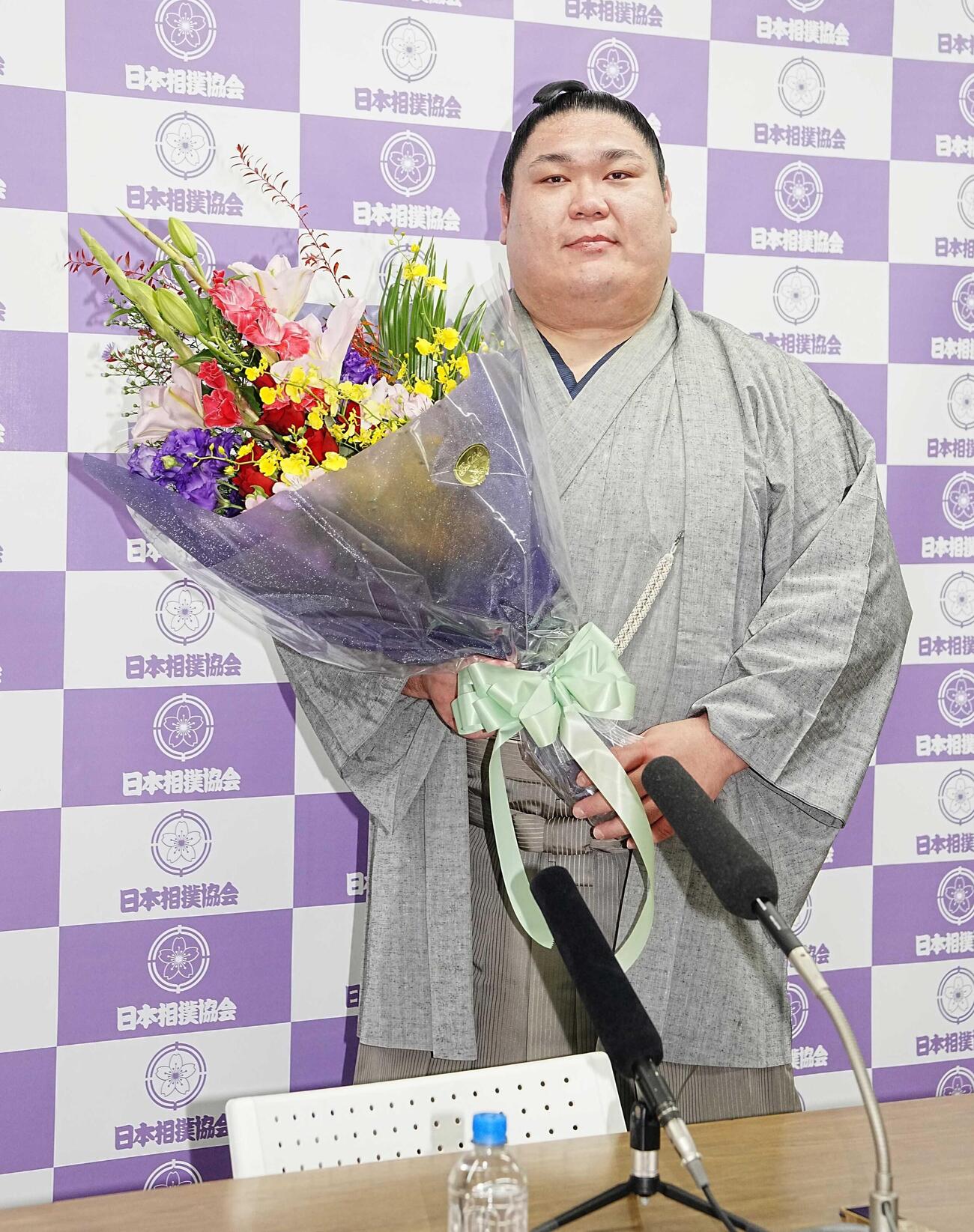 引退会見で花束を手に記念撮影する矢後（撮影・小沢裕）