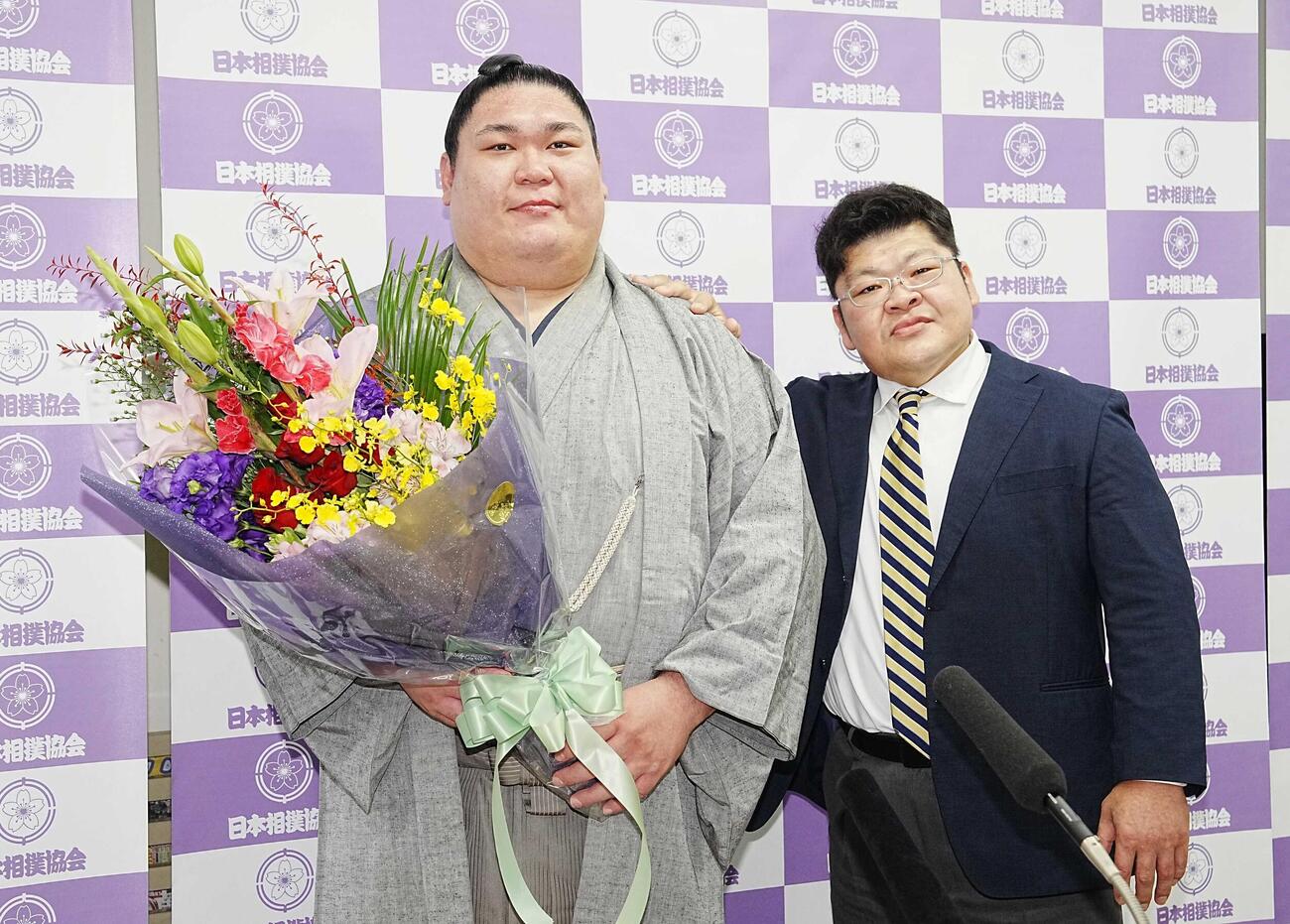 引退会見で花束を手に師匠の押尾川親方（右）と記念撮影する矢後（撮影・小沢裕）