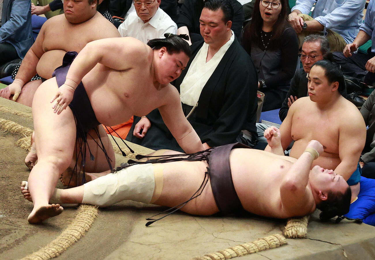 朝乃山（右）を寄り倒しで破る義ノ富士（撮影・中島郁夫）