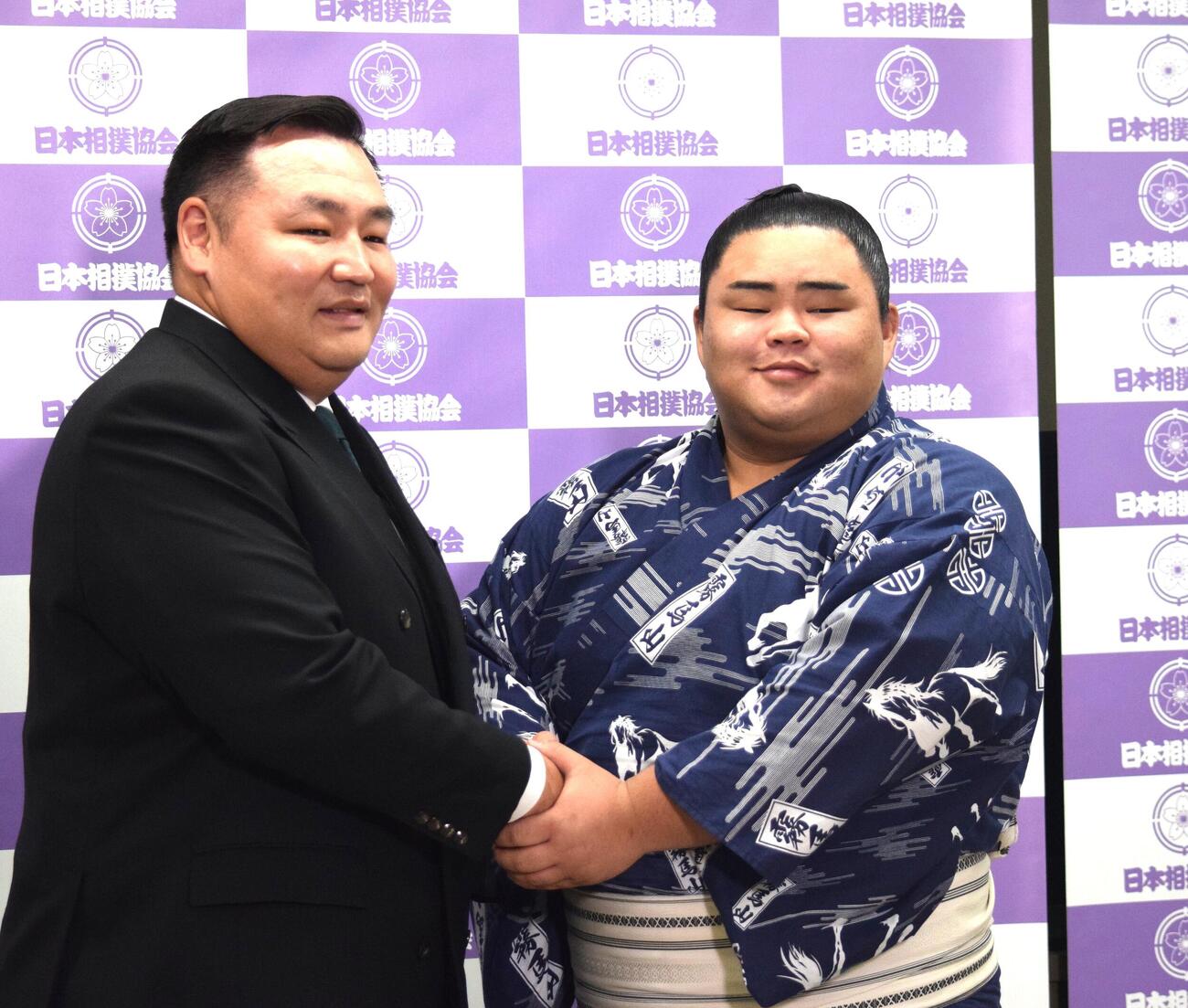 会見後に握手をする音羽山親方（左）と竜鳳