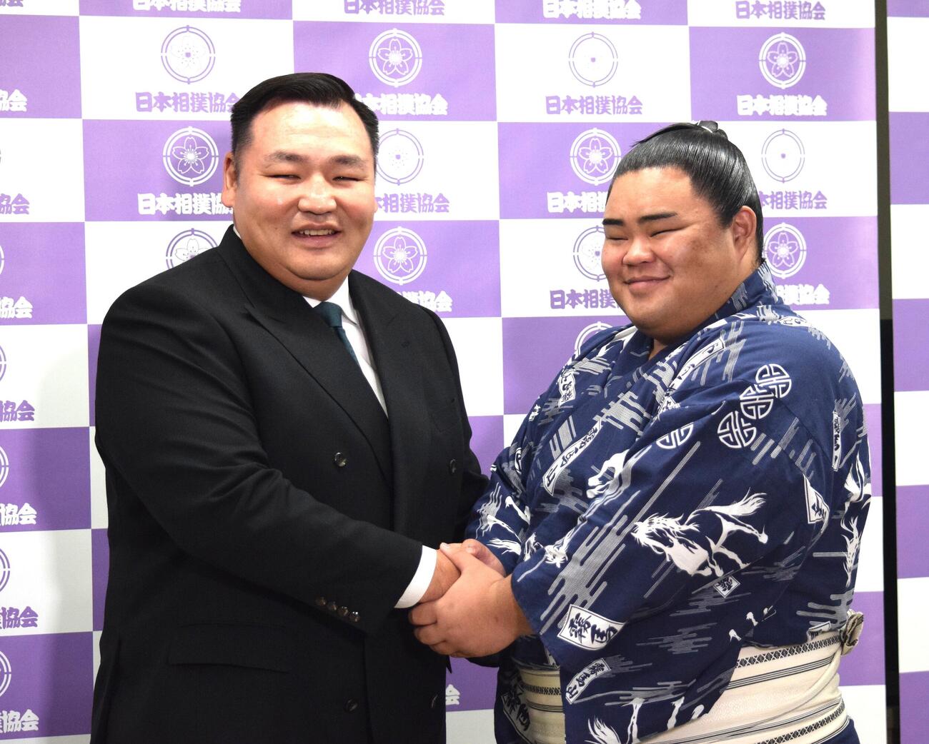 会見後に握手をする音羽山親方（左）と竜鳳