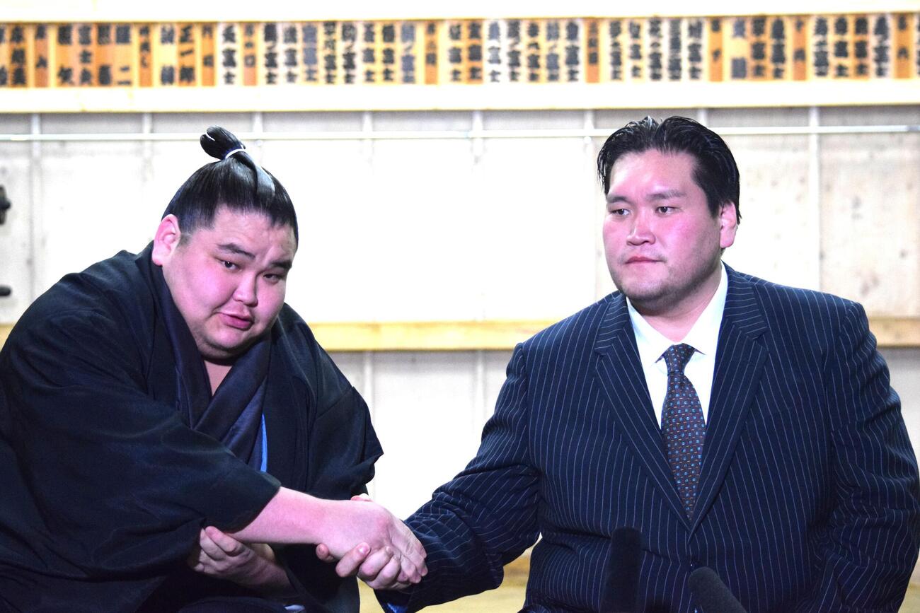 伊勢ケ浜親方（右）と握手する旭富士