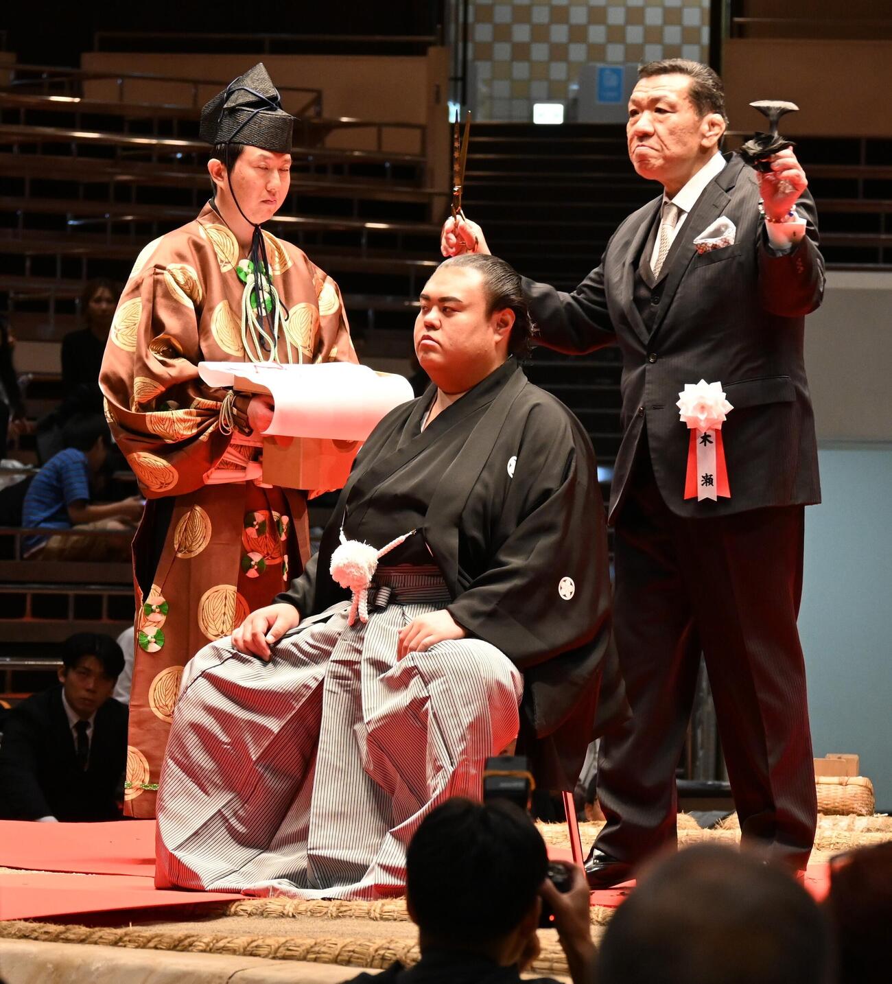 木瀬親方（右）に止めばさみを入れてもらう英乃海