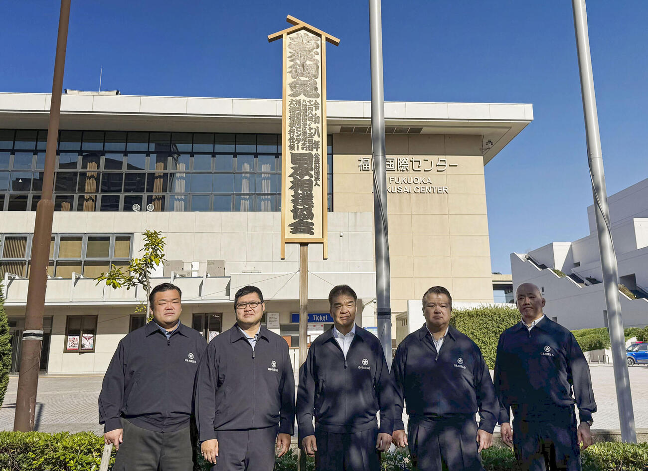 大相撲九州場所の開催を知らせる「御免札」を設置した片男波親方（中央）ら＝8日、福岡国際センター（共同）