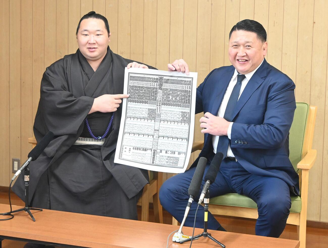 新入幕を果たし番付表を手にする旭海雄（左）と大島親方（撮影・飯岡大暉）