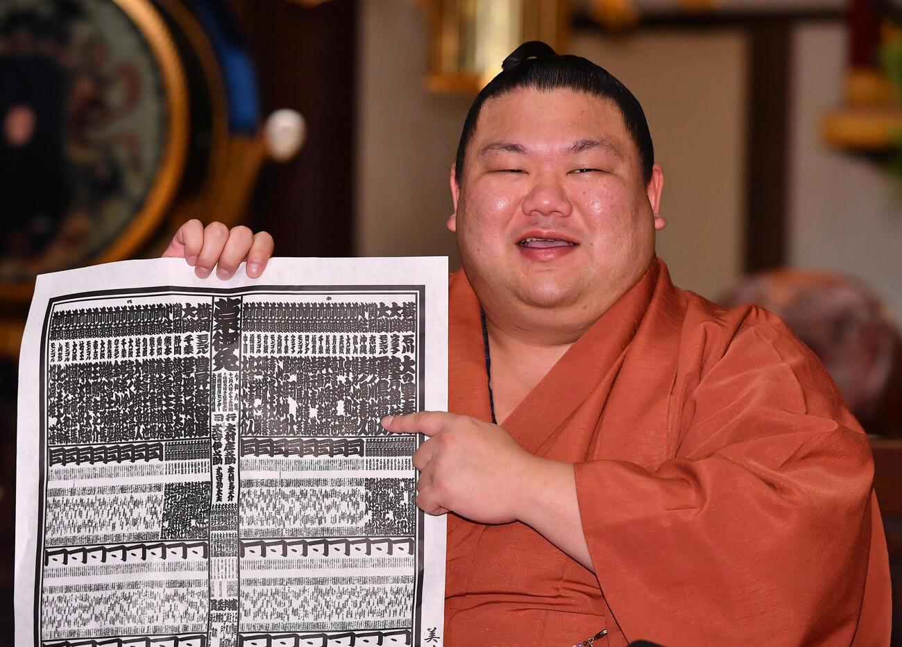 大相撲九州場所の番付表を手に笑顔を見せる美ノ海（撮影・岩下翔太）