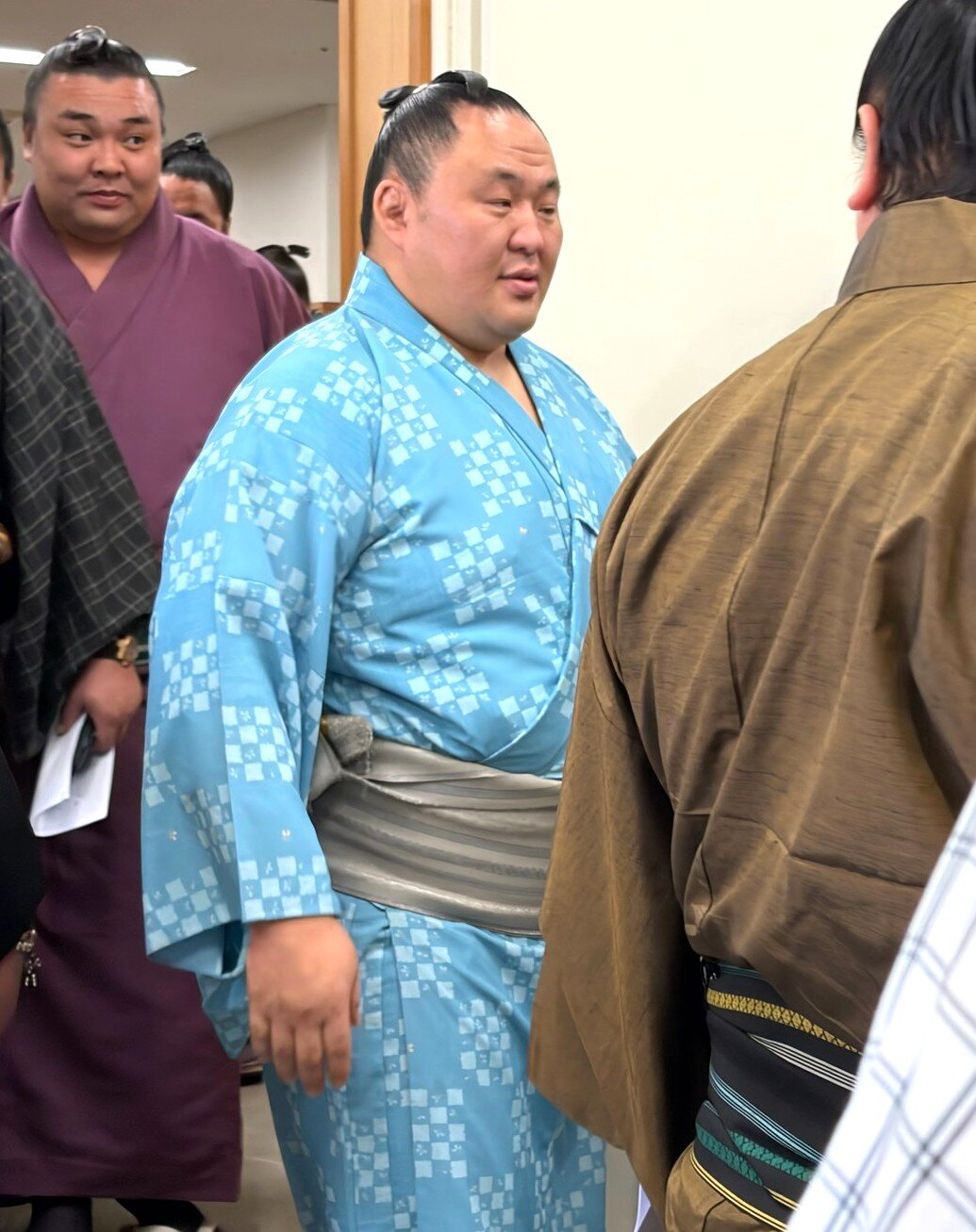力士会を終え退室する玉鷲。後ろは霧島