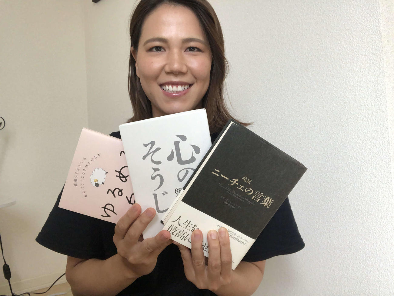 お気に入りの本、左から「ゆるめる自分」「心のそうじ」「ニーチェの言葉」の3冊を手にする景山恵選手
