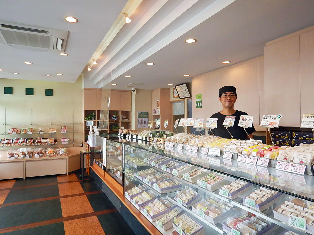 定番から季節の和菓子まで、常時30商品以上をラインナップ。2代目南雲茂店主の笑顔が絶えない