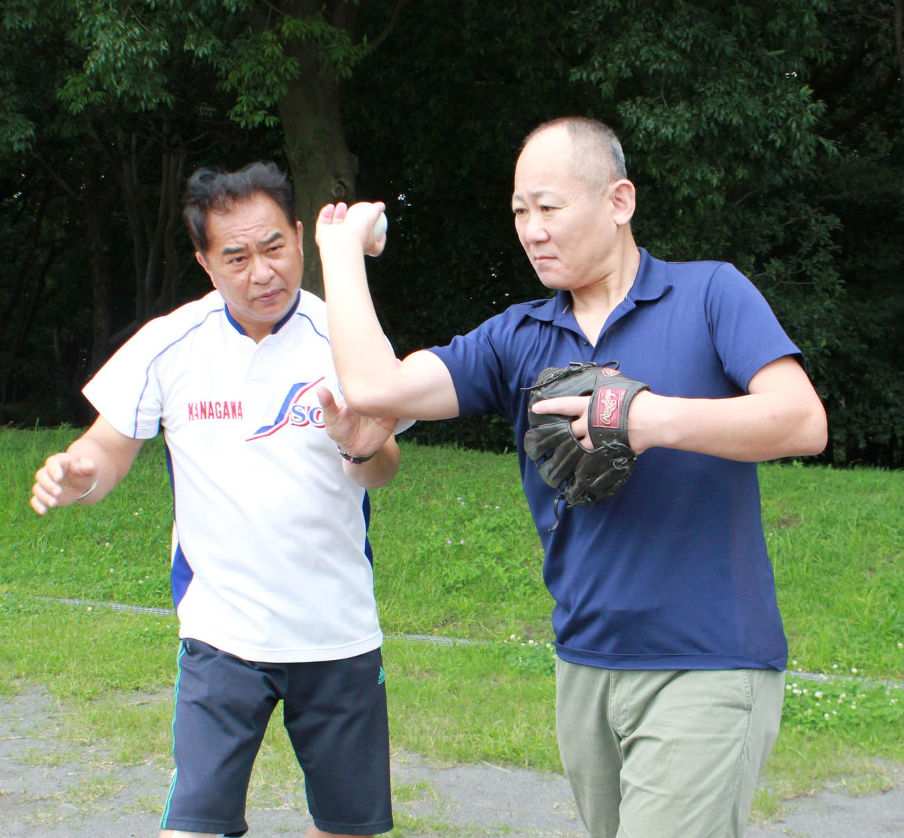 スローイング指導をする著者の河野会長（左）と、企画構成を担当した飯島氏