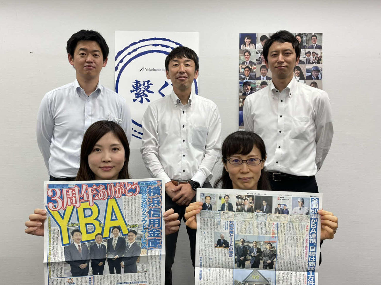 号外を持つYBA事務局の前列左から梶原悠希さん、岸田亜希子さん、後列左から木村俊介サブリーダー、加藤正路チームリーダー、塔ケ埼亮弘さん