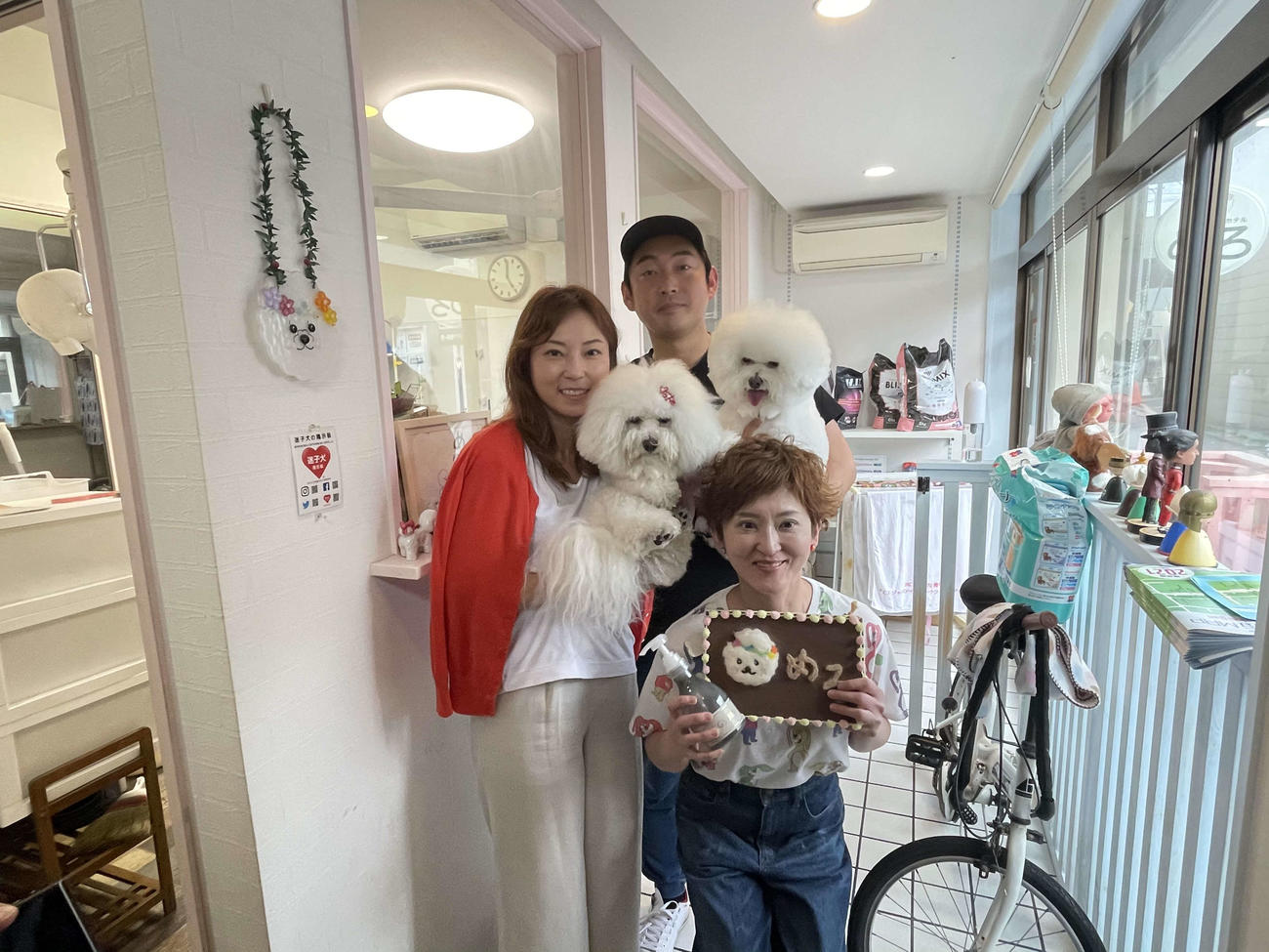 愛犬を抱く工藤裕・千鶴夫妻と、テグスミシャンプーを持つ「めろ」の石村愛代表