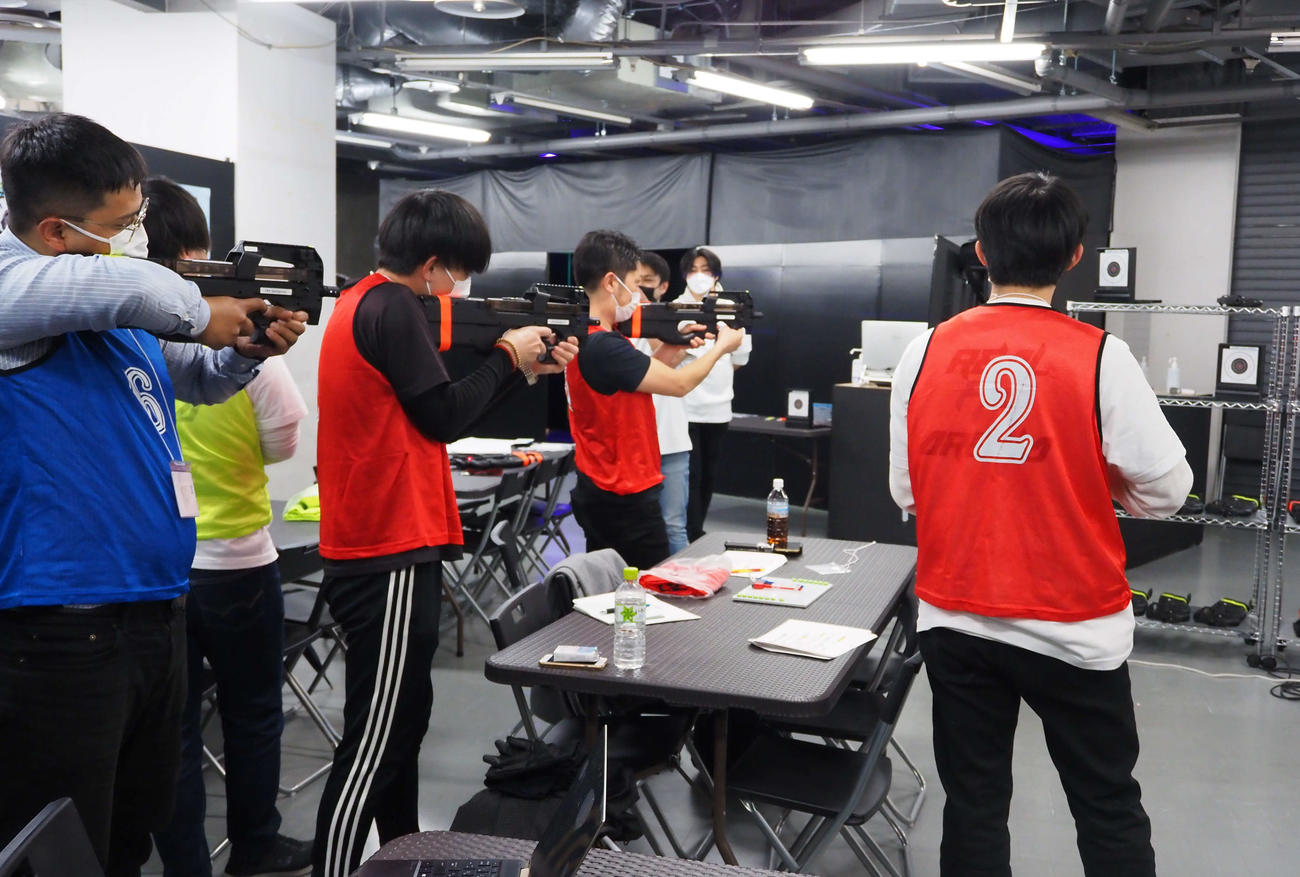 光線銃型の銃を使ったサバゲー研修の参加者たち