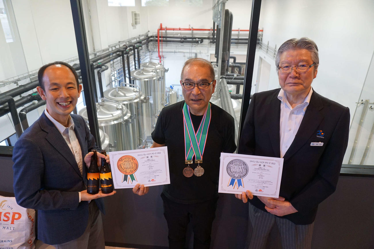 メダルと賞状を喜ぶ右から村山社長、清水氏、立飛麦酒醸造部鶴岡次長