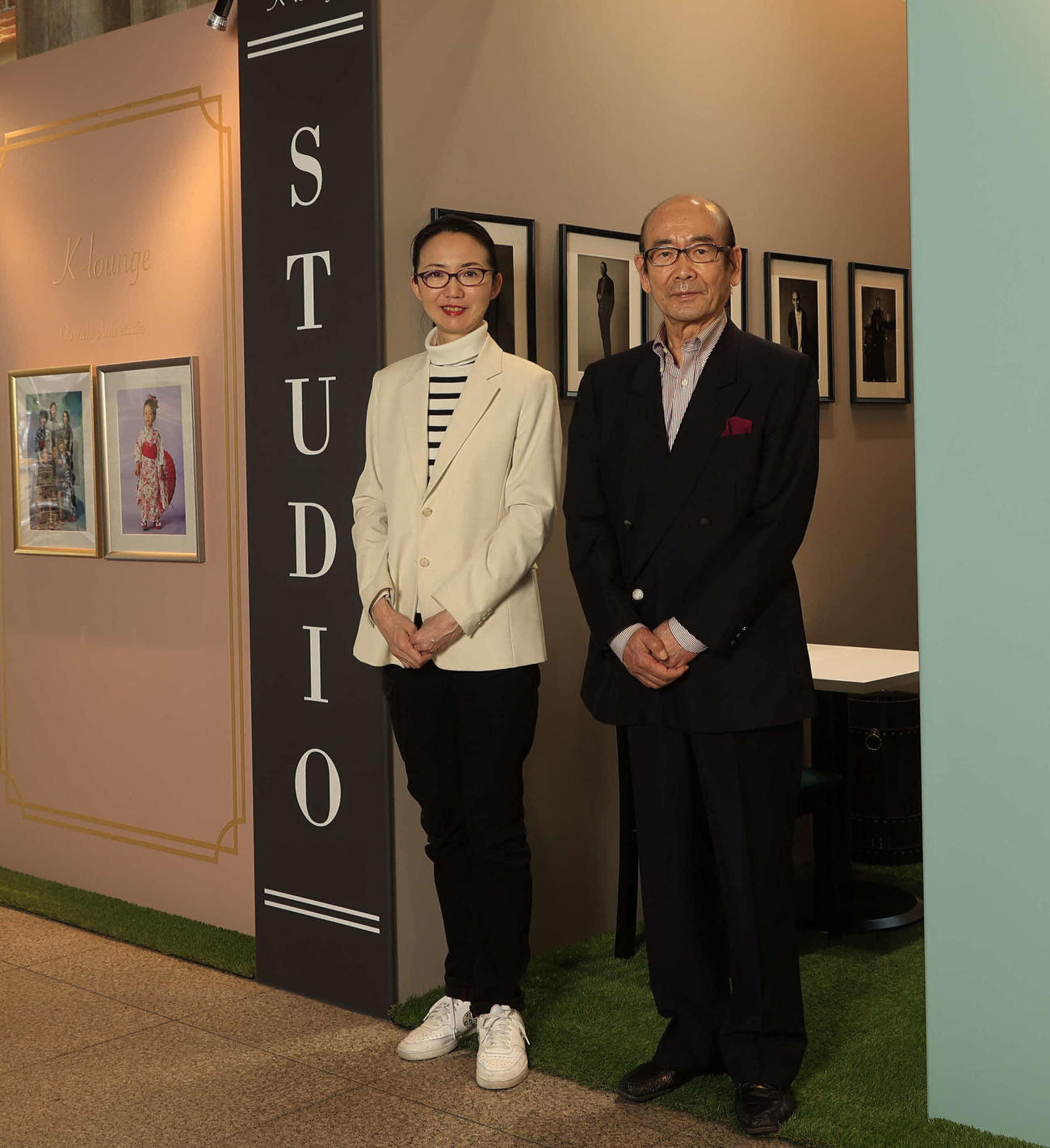 OPSの店舗前に立つ小島社長（右）と公子さん