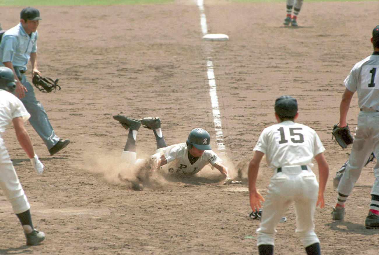 1998年8月20日、延長11回裏、PL学園2死二塁から同点の本塁に飛び込んだ平石主将。右端は横浜・松坂
