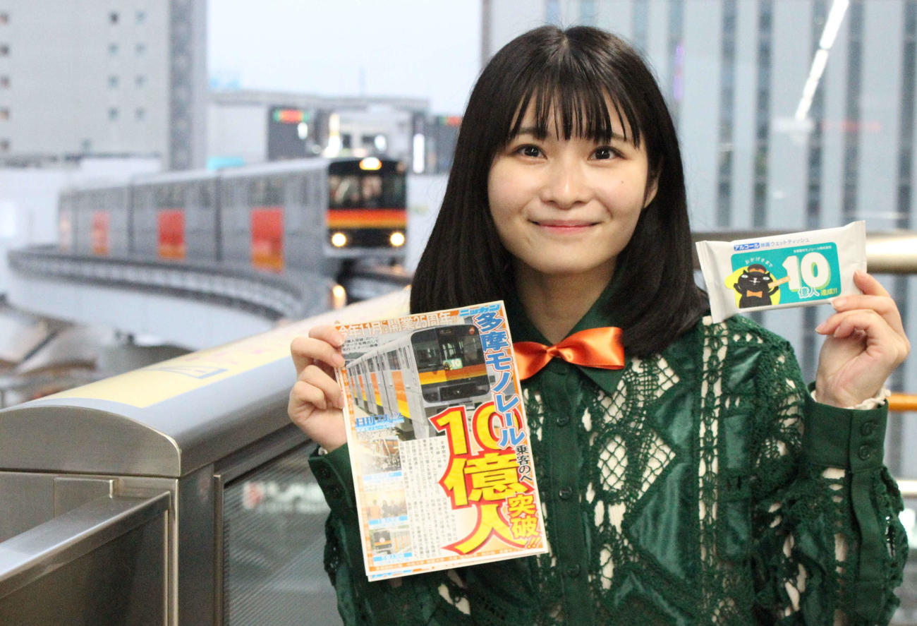 多摩モノレール10億人突破記念本紙ミニ号外と記念品を手にする三田のえ