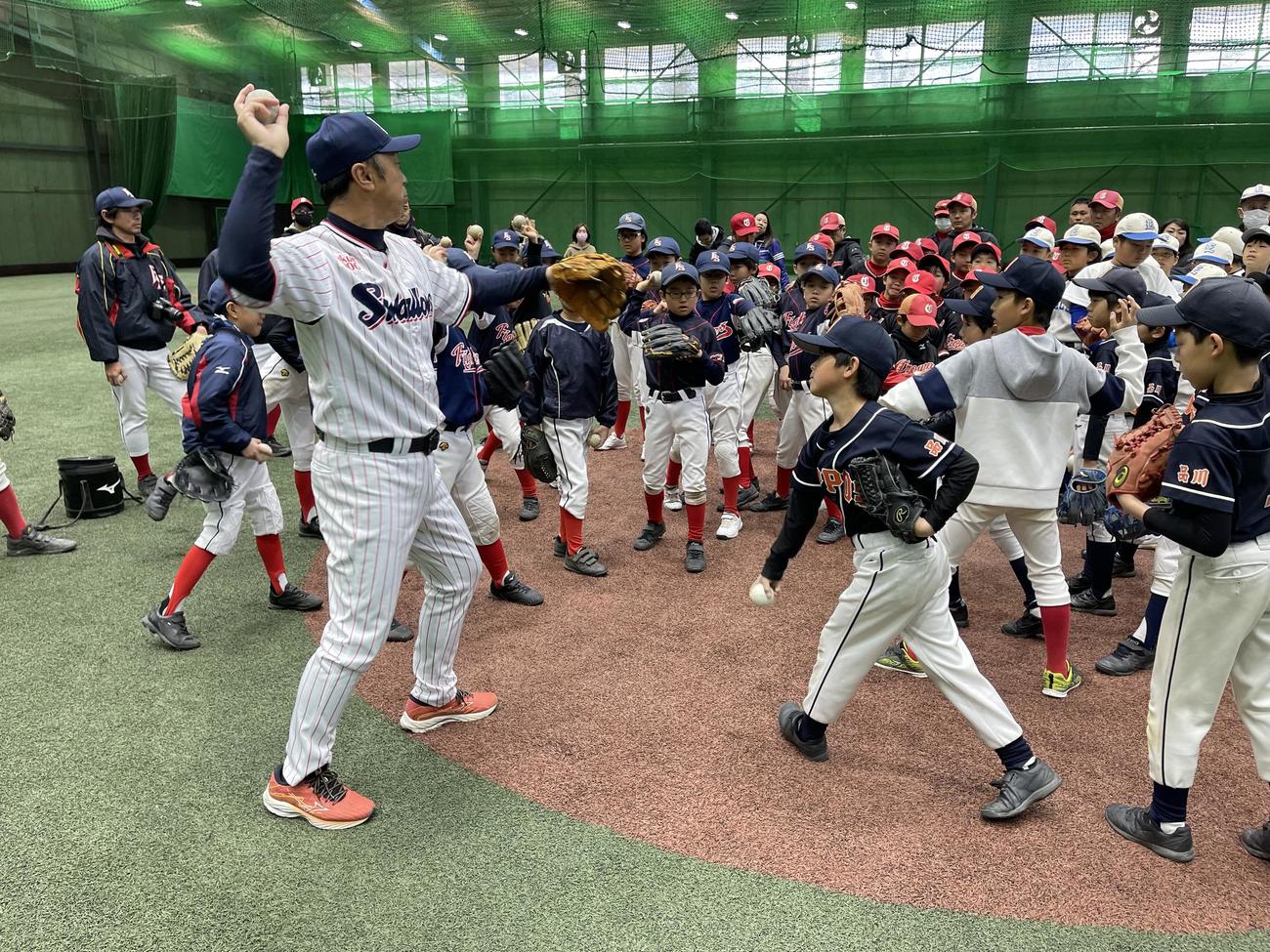 スローイングを指導する宮本慎也氏（左）