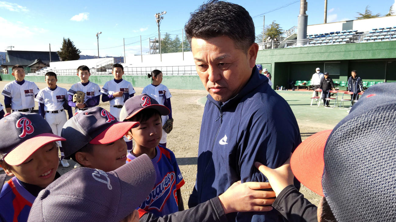 谷繋さんの鍛えた腕を興味深く触る選手たち
