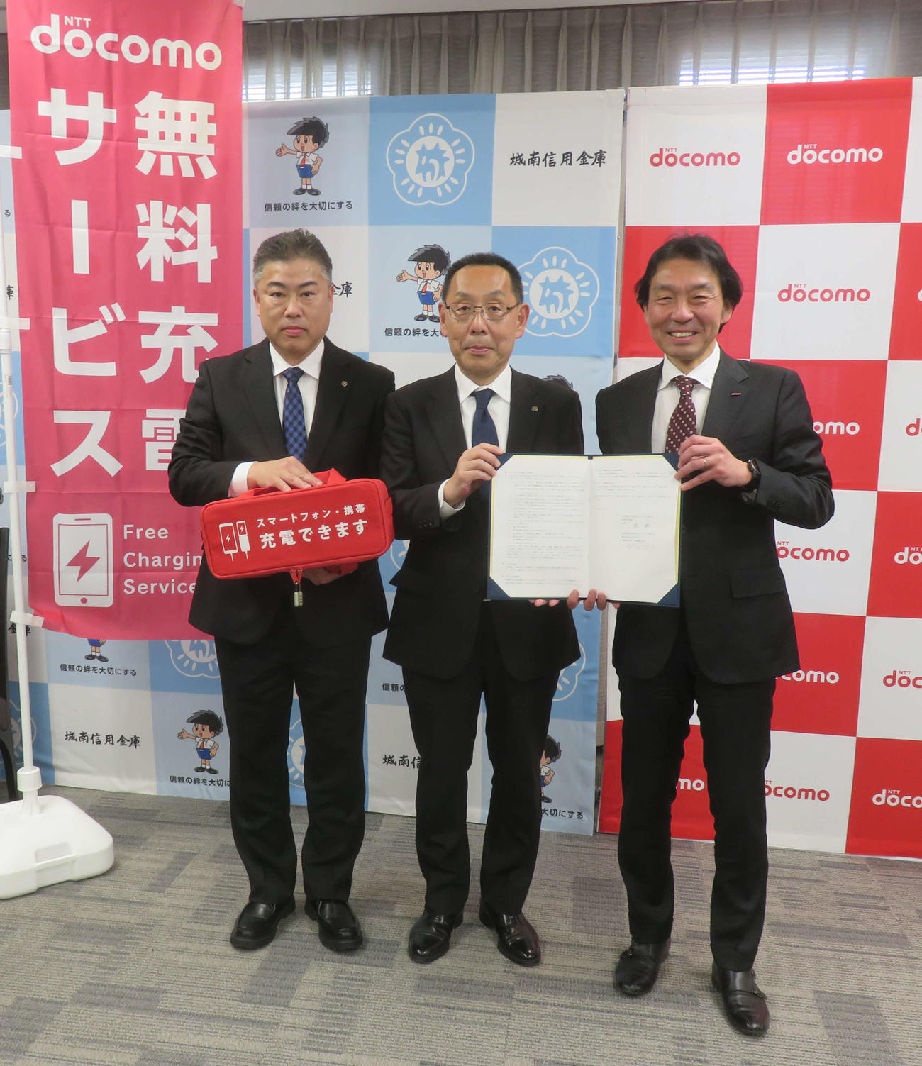 「災害時の連携に関する協定」の調印式を行った城南信用金庫の林稔理事長（中央）とNTTドコモの野田浩人首都圏支社長（右）