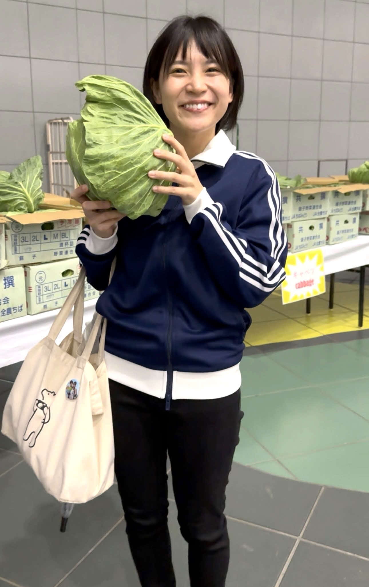 野菜即売会で特大キャベツを手にする飯田あすか