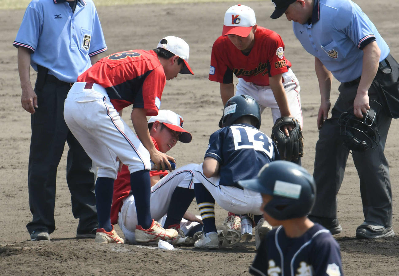 足首に打球が直撃した選手に相手チームのランナーコーチが冷却スプレーを吹きかけた