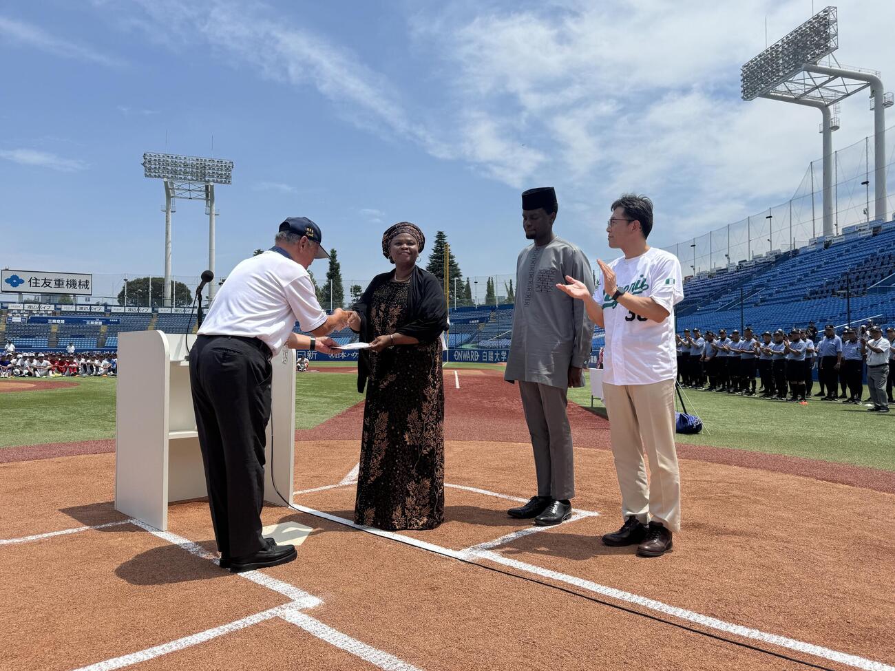 林会長からナイジェリア関係者に野球用具の目録が渡された