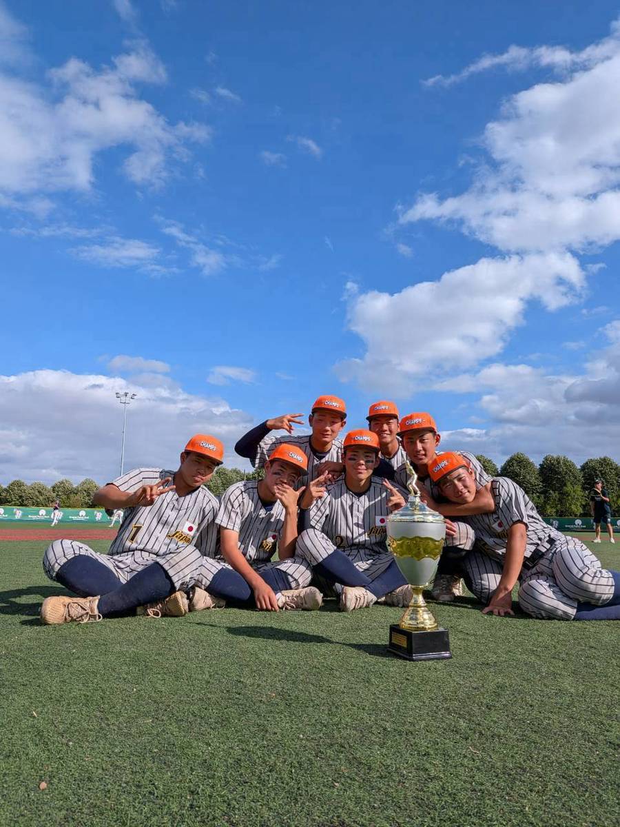 青い空と白い雲をバックに、仲間たちと優勝トロフィーをみつめました