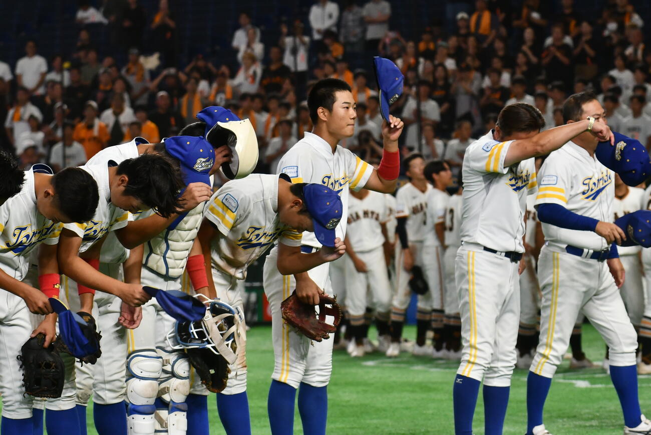 涙を拭う石崎監督（右から２人目）と応援席にあいさつする三ツ井主将（同３人目）ら